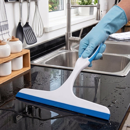 Handheld plastic squeegee wiper cleaning a kitchen countertop