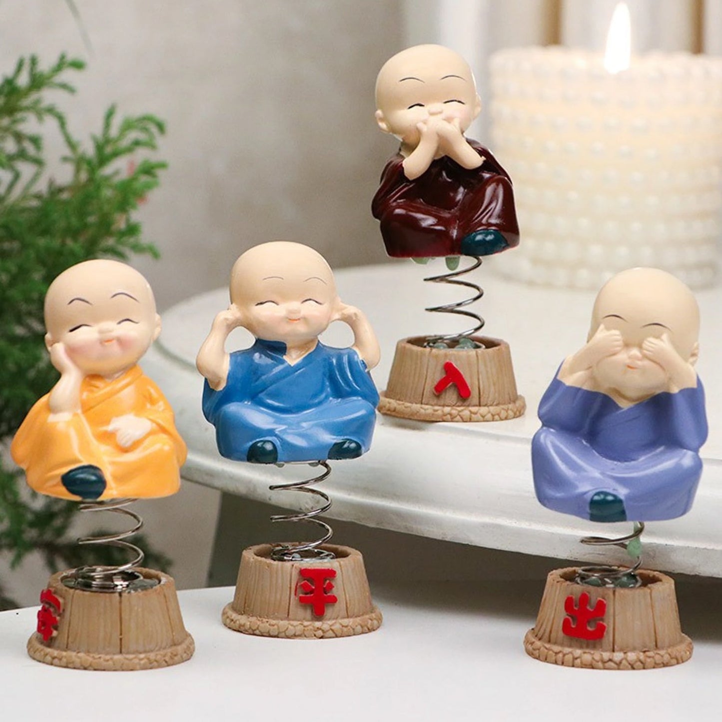 Baby monk figurines displayed on a car dashboard
