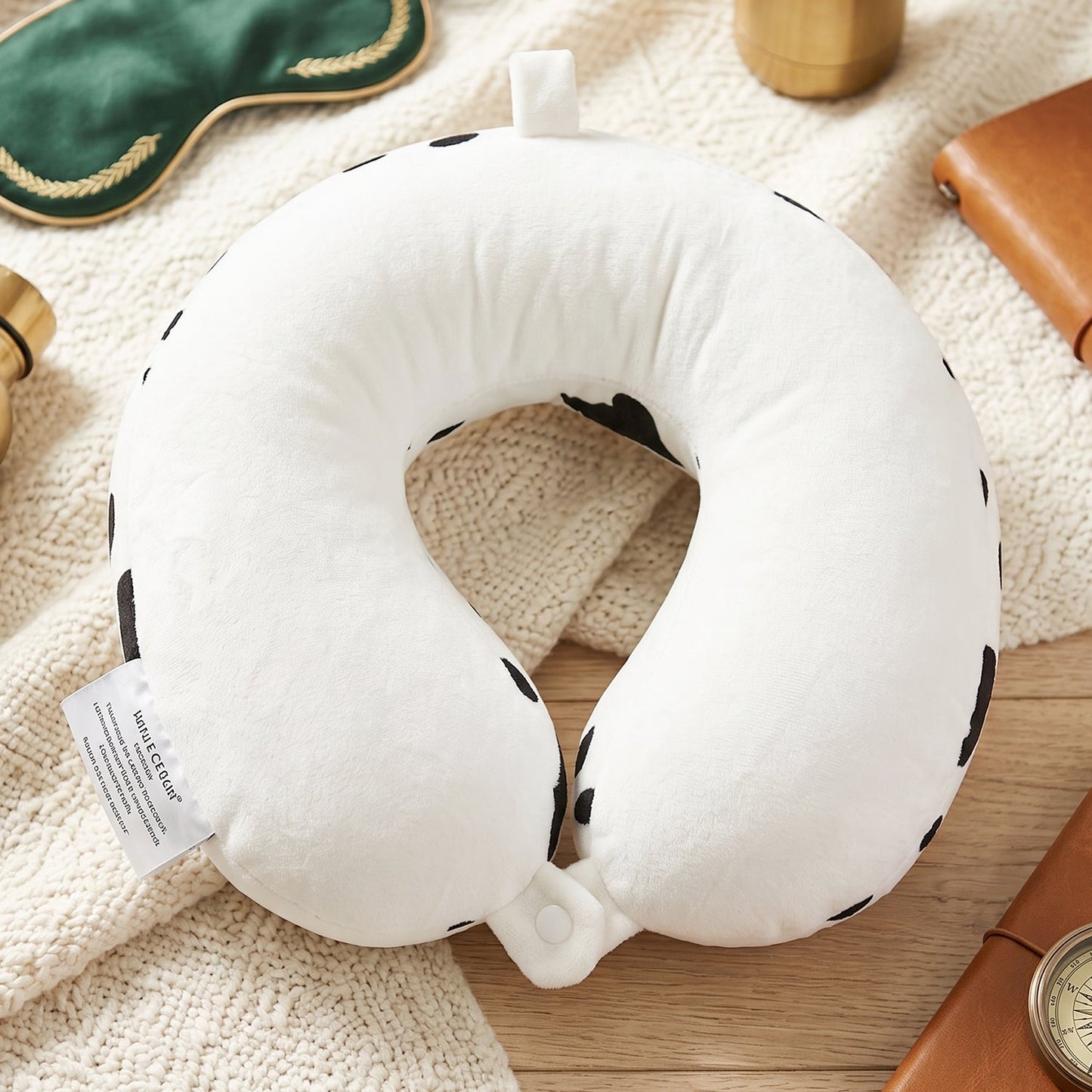 Plush cow print travel cushion for napping on journeys