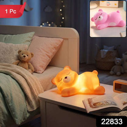 Soft silicone sleeping bear night light providing a warm LED glow.